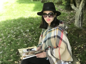 Dettaglio di un poncho con cappuccio a quadri colorati con frange e morbido effetto cashmere