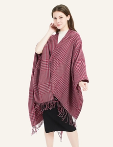 Detailed view of red and grey houndstooth knit poncho with fringe edges for women