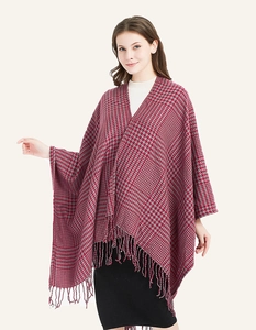 Close-up of red and grey houndstooth knit shawl with long fringe tassels detail