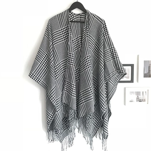 Classic black and white houndstooth knit shawl with fringe and open front design