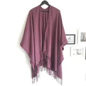 Detail of burgundy and gray houndstooth poncho shawl with delicate tassel hem and fringe