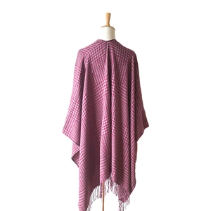 Detailed view of magenta and grey houndstooth knit shawl with long fringe tassels