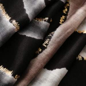 Detail eines Baumwoll-Leinen-Schals mit schwarzen und beigen Streifen und Goldfolie