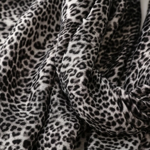 Macro detail of leopard print scarf fabric showing soft weave texture in grey and black