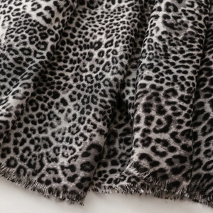 Detail of grey leopard print cotton scarf showing soft texture and fine fringe edge