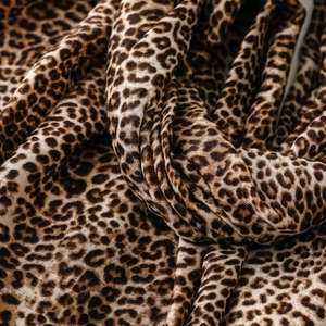 Detailed close-up of leopard print pattern and woven texture on a cotton-linen scarf