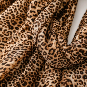 Detail shot of leopard print scarf fabric showing brown animal pattern and texture