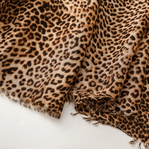 Close-up of leopard print cotton-linen scarf showing soft texture and raw fringe edges