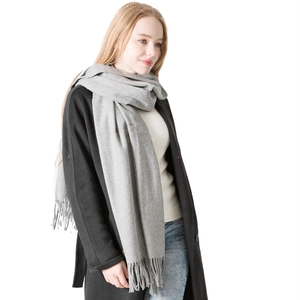 Classic grey cashmere wool scarf with fringe styled on a black coat for autumn winter