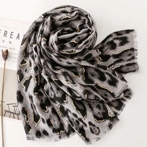 Gray and black leopard print scarf with gold metallic accents and frayed tassel edges