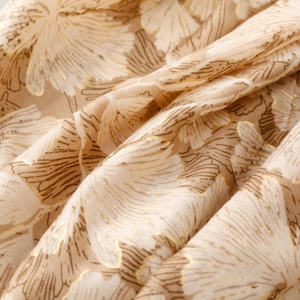 Detail of soft satin cotton scarf featuring gold foil floral prints and smooth texture