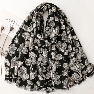 Close-up of black and white ginkgo leaf print cotton linen scarf with frayed edges