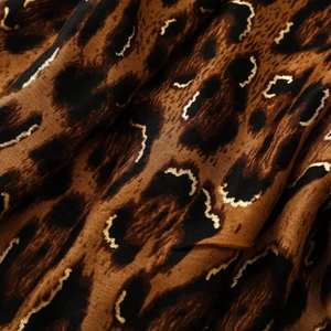 Close-up of leopard print fabric with metallic gold thread embroidery detail