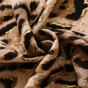 Detailed macro shot of leopard print scarf fabric with golden foil metallic texture