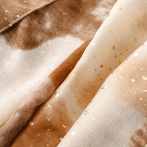 Macro detail of brown gradient satin cotton scarf with elegant gold foil spots