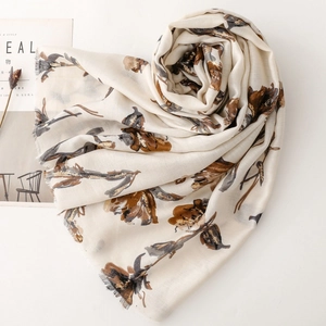 Detail of floral printed scarf with golden foil accents and soft fringe edges