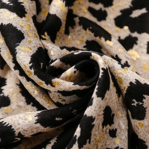 Macro detail of leopard print scarf featuring gold foil accents and soft cotton texture
