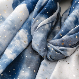 Detailed close-up of blue and white gradient scarf with gold foil dots and soft fringe