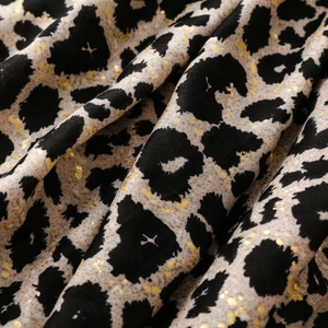 Macro view of leopard print scarf fabric with gold foil accents and soft texture