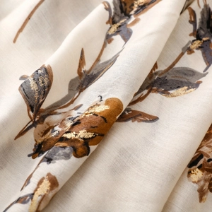 Macro shot of cotton linen scarf featuring elegant floral patterns and golden foil details
