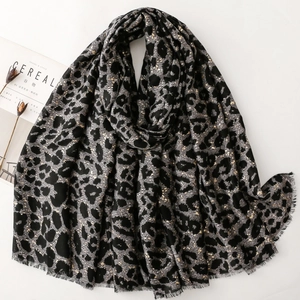 Soft leopard print scarf with gold foil accents and raw fringe edges in black and grey