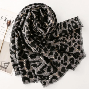Close-up of leopard print scarf with gold foil accents and raw frayed edges detail
