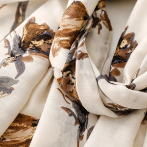 Macro detail of satin cotton linen scarf with elegant gold foil flower printing