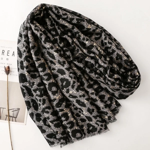 Macro detail of leopard print scarf with gold foil accents and natural fringed edges