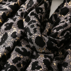 Macro shot of soft leopard print fabric with metallic gold foil dots and elegant drape