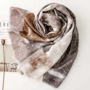Detail of gradient cotton linen shawl with gold foil accents and frayed edges