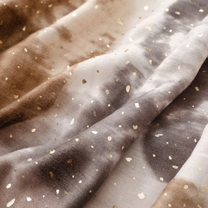 Close-up of soft gradient linen scarf with gold foil dots and artistic ink wash texture