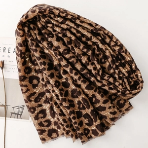 Close-up of leopard print scarf with gold foil accents and natural fringed edges