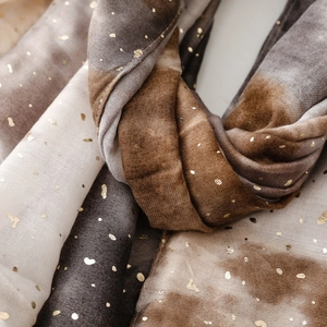 Detail of soft cotton linen scarf featuring gradient hues and gold foil heart patterns