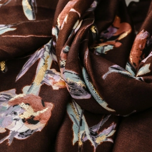 Macro shot of dark brown scarf with floral prints and fine golden bronzing details