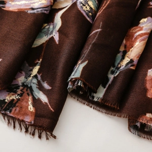 Detail of floral printed cotton linen scarf with gold foil accents and fringe edges