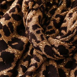 Detailed macro shot of leopard print scarf fabric with subtle gold foil accents