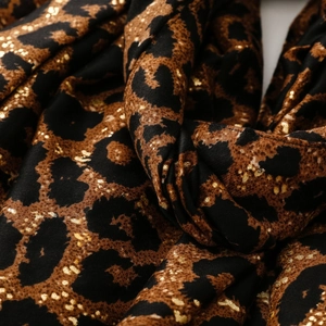 Detailed view of leopard print scarf featuring gold foil accents and soft cotton linen texture