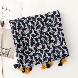 Detail of bohemian scarf with navy ginkgo print and colorful tassels on fabric edge