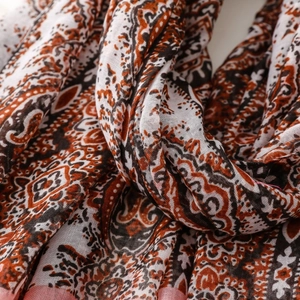 Detailed close-up of paisley pattern and texture on cotton-linen scarf for beach vacations