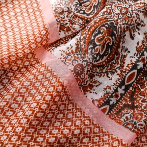 Detailed macro view of bohemian cotton-linen scarf with paisley and geometric patterns