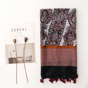 Detail of bohemian paisley shawl with tassel fringe on a minimalist background