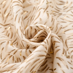 Macro shot of cotton linen scarf texture featuring gold foil accents and leaf vein print