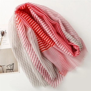Detailed macro view of red striped cotton linen scarf with fine tassel edge and soft texture