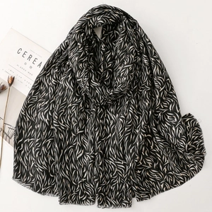 Soft black cotton linen scarf with elegant gold leaf print and frayed edges for women