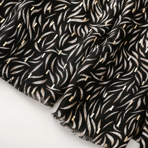 Macro detail of soft cotton-linen scarf with golden foil bird nest and geometric patterns