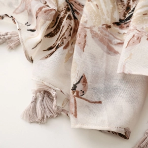 Macro detail of leaf pattern print and handcrafted braided tassels on cotton-linen shawl