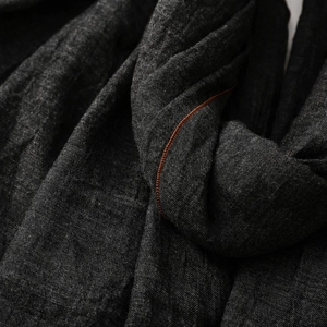 Detail eines grauen Baumwoll-Leinen-Schals mit Kontrastnaht in Orange und Stoffstruktur