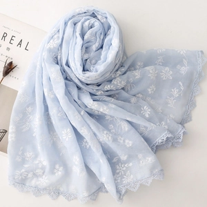 Detailed view of light blue floral scarf featuring delicate white flowers and lace trim