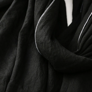 Detailaufnahme des schwarzen Baumwoll-Leinen-Schals mit Webstruktur und feiner Overlock-Naht