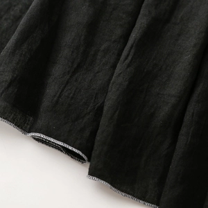 Makrodetail aus schwarzem Baumwoll-Leinen-Stoff mit ordentlicher hellgrauer Overlock-Naht